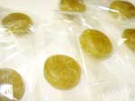 『びわの葉茶飴』の写真　緑色のびわの葉茶飴が透明の袋に個包装されています。